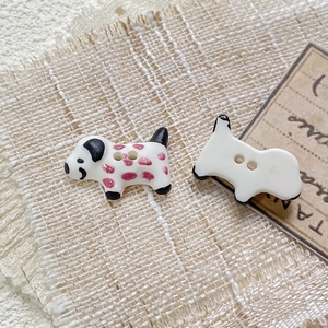 Macro detail of hand-painted ceramic dalmatian puppy beads for DIY jewelry making