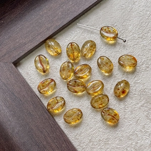 Macro shot of amber glass coffee bean beads with realistic texture and polished finish