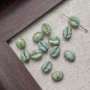 Macro detail of coffee bean glass beads with retro blue glaze and kiln-changed texture