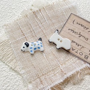 Macro shot of hand-painted ceramic dalmatian and dog shaped beads for DIY jewelry making