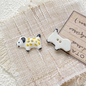 Macro shot of hand-painted ceramic dalmatian puppy buttons for DIY jewelry making