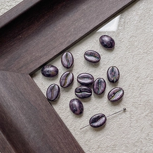 Macro shot of iridescent purple coffee bean beads for DIY jewelry and crafts