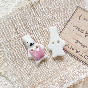 Macro shot of hand-painted ceramic rabbit buttons showing front design and back dual holes