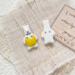 Detailed macro view showing front and back of handmade ceramic rabbit bead with sewing holes