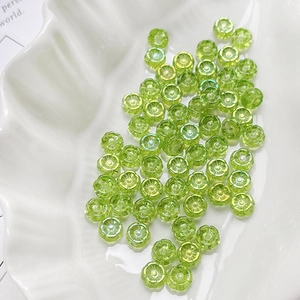 Detailed view of translucent pale green flower-shaped glass beads for jewelry making