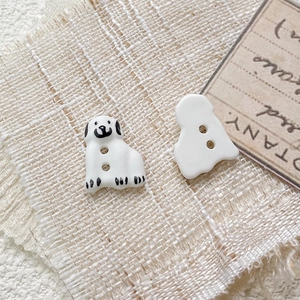Macro detail of hand-painted ceramic dalmatian puppy beads with dual-hole design for DIY crafts