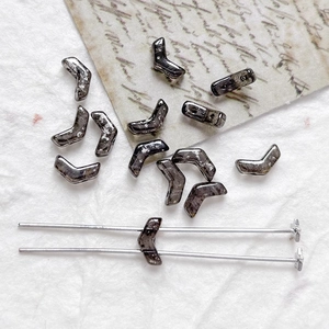 Detail of silver-spotted V-shape Czech glass beads with two-hole structure for DIY jewelry