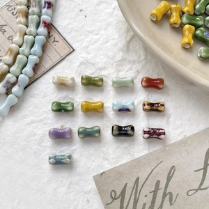 Close-up of colorful dumbbell-shaped ceramic beads with glazed patterns for DIY jewelry