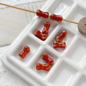 Detailed macro view of bone-shaped red ceramic beads for DIY jewelry making