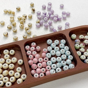 Detailed view of assorted handmade celadon ceramic beads with colorful glaze for DIY jewelry