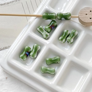Macro shot of green bamboo bone shaped ceramic beads for DIY jewelry making