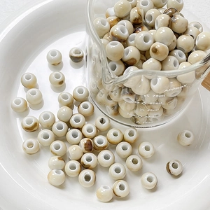 Close-up of celadon glazed ceramic beads with brown marble texture for DIY jewelry