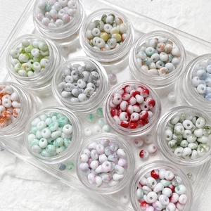Multi-colored 4mm glass seed beads in storage containers for DIY jewelry making