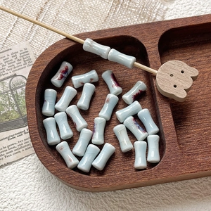 Detail of hand-painted bamboo-shaped ceramic beads with cracked glaze for jewelry making