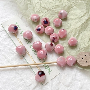 Detailopname van roze gebloemde keramische kralen voor DIY sieraden maken
