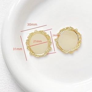Macro view of 18k gold plated baroque style oval pendant frames with ornate floral relief