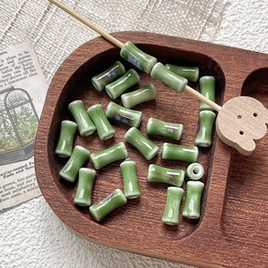 Macro shot of bamboo-shaped green ceramic beads with kiln-effect glaze for DIY jewelry