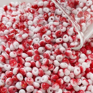 Macro shot of 4mm cream-textured glass beads with red-white gradient and gold foil