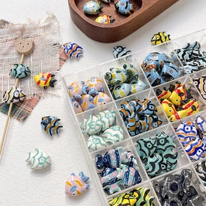 Detailed view of hand-painted tropical fish ceramic beads for DIY jewelry making
