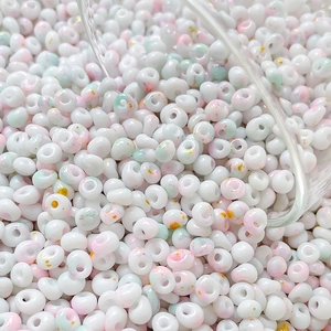 Detailed macro view of 4mm creamy white glass beads with gold foil for DIY jewelry making