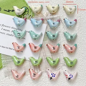 Detail van handbeschilderde keramische kralen in duifvorm voor DIY sieraden in diverse kleuren