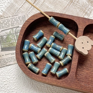 Macro shot of blue cylindrical ceramic bamboo beads with vintage speckled glaze texture