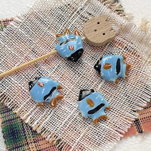 Macro detail of hand-painted ceramic tropical fish beads for DIY jewelry making and crafts