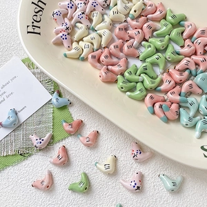 Handbeschilderde kleurrijke keramieken vogel kralen voor DIY sieraden op een wit bordje
