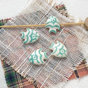 Macro detail of hand-painted tropical fish ceramic beads for DIY jewelry making