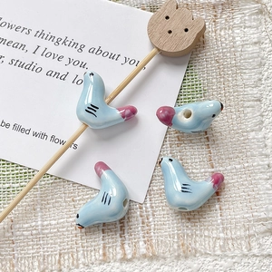 Macro-opname van blauwe keramische vogelkralen met glazuurdetails voor DIY-sieraden