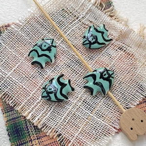Macro shot of hand-painted tropical fish ceramic beads for DIY jewelry making