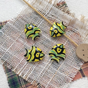 Detail of hand-painted ceramic tropical fish beads for DIY jewelry and necklaces