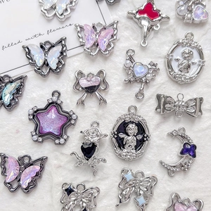 Détail de breloques bijoux DIY avec motifs papillon, étoile et ange en métal argenté