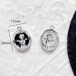 Vue détaillée des pendentifs ange vintage 24mm avec bordures baroques en métal argenté