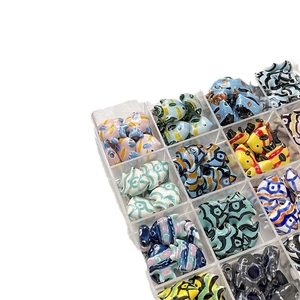 Hand-painted ceramic tropical fish beads for DIY jewelry making in a plastic organizer box