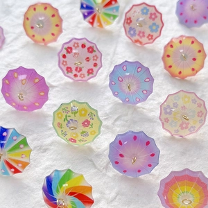 Macro shot of colorful resin mini umbrella charms with floral prints and metal rings
