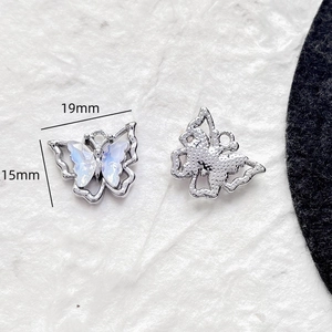 Vue macro d'un pendentif papillon de 19x15mm avec incrustation irisée argentée