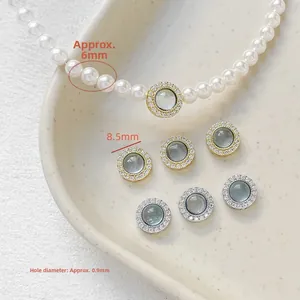 Macro shot of 8.5mm gold and silver spacer beads with zircon inlays and 6mm pearls