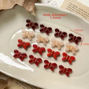 Detailed view of red butterfly Czech glass beads with gold trim for DIY jewelry