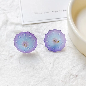 Close-up of DIY resin umbrella charms with purple and blue gradient and gold hooks