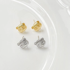 Panda oorknopjes verguld met 18k goud en zilver in een witte keramische schaal