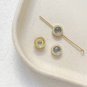 Macro detail of gold-plated spacer beads with micro-set zircons and sea blue stones