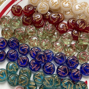 Detailed macro view of Czech glass beads with hand-painted bird motifs for jewelry making