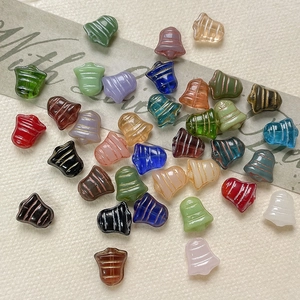 Macro detail of colorful bell-shaped Czech glass beads with golden spiral craft lines