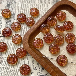 Detailed macro view of amber glass beads with bird relief for DIY jewelry making