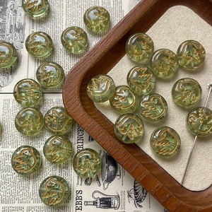 Macro shot of light green glass bird bead with gold details for DIY jewelry making