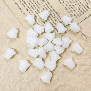 Macro detail of white bell-shaped Czech glass beads for vintage DIY jewelry making