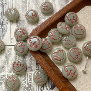 Macro detail of bird engraved glass beads on vintage background for jewelry making