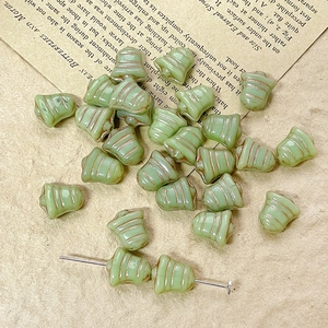 Macro shot of light green vintage bell glass beads with gold trim for DIY jewelry making