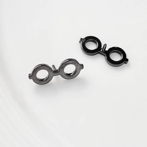 Detailed view of minimalist round-frame eyewear stud earrings in dark gunmetal finish